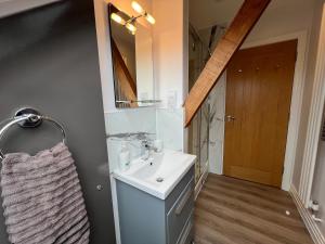 une salle de bain avec un lavabo et un miroir dans l'établissement Glastonbury Secret Retreat - 1 BD Split-Level Apt, Sleeps 3, à Glastonbury