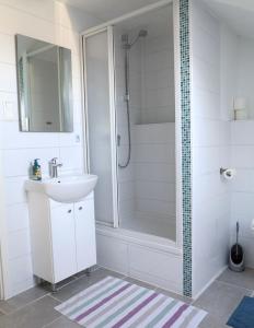 a white bathroom with a shower and a sink at Hike 'n Bike Base in Bad Kohlgrub