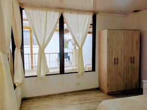 a bedroom with a bed and a large window at Alojamiento Parque La Libertad in Cuenca +2 photos