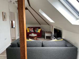 ein Wohnzimmer mit einem Sofa und einem Tisch in der Unterkunft Glastonbury Town Centre - Split-Level 1 Bedroom Apartment in Glastonbury