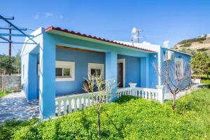 a blue and white house with a white fence at Villa Lothiko in Karpathos Town