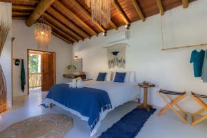 Schlafzimmer mit einem Bett mit blauer Decke in der Unterkunft Villa Mediterrâneo Trancoso in Trancoso