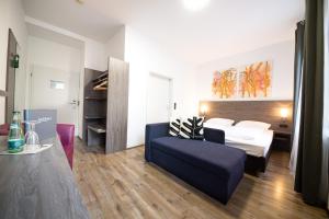 um quarto de hotel com uma cama e um sofá em ArtHotel City em Nurembergue