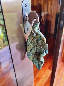 a metal door knob with a leaf on it at Onca Tours & Treehouses in San Rafael
