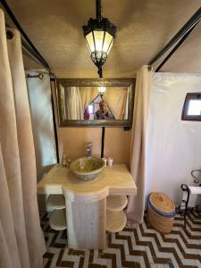 a person taking a picture of a bathroom with a sink at Erg Chebbi Sahara Camp in Merzouga