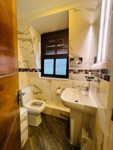 a bathroom with a toilet and a sink and a window at Private Room@LeicesterSquare in a Shared Flat in London