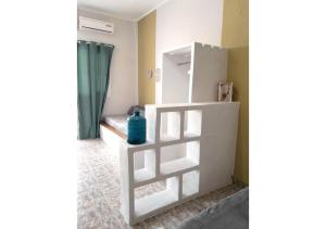 ein Zimmer mit einem weißen Regal mit einer blauen Flasche darauf in der Unterkunft Overhill Apartments Adamas in Adamas