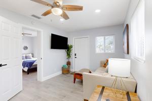 uma sala de estar com um sofá e uma ventoinha de tecto em Palm Place em Lake Worth