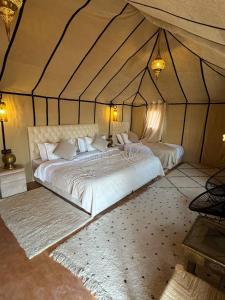 a bedroom with a large bed in a tent at Erg Chebbi Sahara Camp in Merzouga