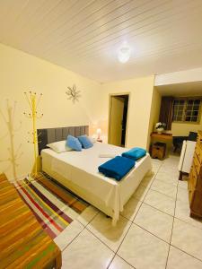 een slaapkamer met een bed met blauwe kussens erop bij Hospedaria Vila Rica in Ouro Preto