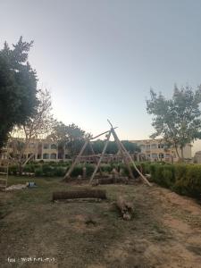 a pile of logs in a yard with a playground at Oasis Panorama Hotel in Bawati