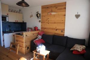 un salon avec un canapé noir et une cuisine dans l'établissement Résidence Plein Soleil Ii - studio cabine 4 personnes MAE-2800, à Orcières