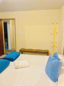 a bedroom with two beds with blue pillows at Hospedaria Vila Rica in Ouro Preto