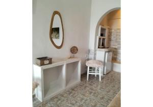 Zimmer mit einem Tisch, einem Spiegel und einem Stuhl in der Unterkunft Overhill Apartments Adamas in Adamas