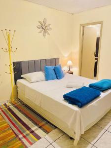 a bedroom with a large bed with blue pillows at Hospedaria Vila Rica in Ouro Preto
