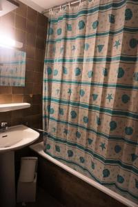 a bathroom with a shower curtain and a sink at Résidence Rond Point I - Studio pour 4 Personnes 192842 in Orcières