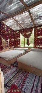 a room with two beds and a rug at siwa gardenia cottage in Siwa