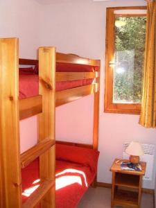 een slaapkamer met 2 stapelbedden en een raam bij Les Chalets D'arrondaz - 4 Pièces pour 8 Personnes 03 in Modane