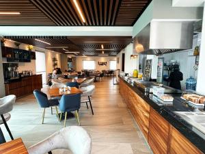 un restaurante con un bar con gente sentada en las mesas en Hotel Fray Select en Tepic