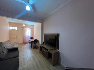 sala de estar con sofá y TV de pantalla plana en Quarto simple em Ipanema, en Río de Janeiro