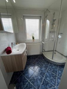 a bathroom with a sink and a shower and a tub at Ferienhaus in zentraler Lage zwischen Goitzsche und Wörlitz in Steinfurth