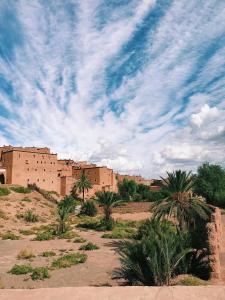 uma cidade no deserto com palmeiras e edifícios em WARZAZAT Hostel em Uarzazate