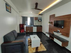 a living room with a couch and a tv at 11. 101@HSR Premium Fully Furnished 1BHK Flat in Bangalore