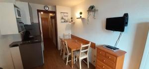 een kamer met een tafel en een keuken met een televisie bij Chalet Club - Studio pour 3 Personnes 80 in Modane