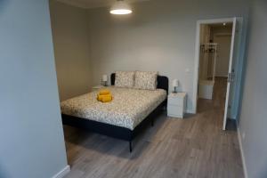 a bedroom with a bed with two yellow pillows on it at Alma Beach House in Costa da Caparica