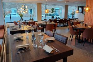 ein Esszimmer mit Holztischen und -stühlen sowie ein Restaurant in der Unterkunft Best Western Hotel Trollhattan in Trollhättan