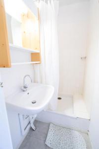 een witte badkamer met een wastafel en een douche bij Résidence Grand Argentier - 4 Pièces pour 10 Personnes 193097 in Modane