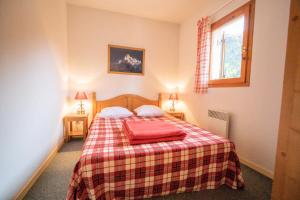 um quarto com uma cama com um cobertor xadrez em Résidence Belvedere Busseroles - 3 Pièces pour 6 Personnes 193112 em Modane