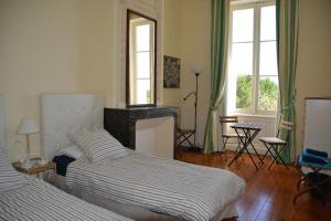 - une chambre avec 2 lits, une cheminée et des fenêtres dans l'établissement Château La Tuilière Villa with pool and it's own wineyard, à Saint-Ciers-de-Canesse