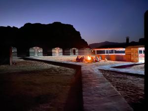 a fire pit in front of a building at night at Wadi Rum Jordan Camp in Wadi Rum