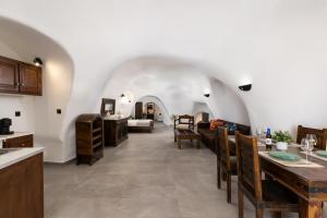 a kitchen and living room with a table and chairs at Enalion Suites in Oia