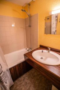 une salle de bain avec un lavabo et une baignoire dans l'établissement Résidence Les Arolles - LES AROLLES - AR36A MAE-3178, à Villarodin-Bourget