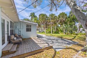 een veranda van een wit huis met een stoel bij 29 Palms in Anna Maria