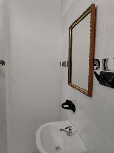 a bathroom with a sink and a mirror at Casa Hospedaje Don Augusto Oxapampa in Oxapampa