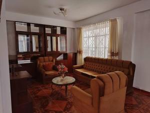 un soggiorno con divano, sedie e tavolo di Casa Hospedaje Don Augusto Oxapampa a Oxapampa