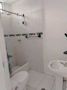 bagno bianco con servizi igienici e lavandino di Casa Hospedaje Don Augusto Oxapampa a Oxapampa