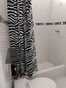 a bathroom with a black and white shower curtain at Casa Hospedaje Don Augusto Oxapampa in Oxapampa