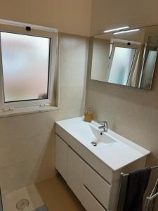 a bathroom with a white sink and a mirror at Cabo Sardão Guest House in Odemira