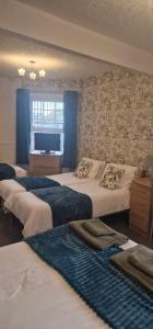 a hotel room with three beds and a television at Hawthorn House in Blackpool +170 photos