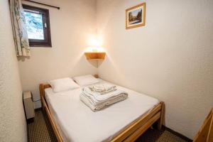 a small bed in a room with a light on it at Résidence Les Epervieres - LES EPERVIERES - EP75A MAE-3180 in Villarodin-Bourget