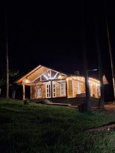 a wooden house with lights on it at night at Oxaturismo Perú in Oxapampa