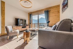 a living room with a couch and a television at Résidence Les Balcons EtoilÉs - 2 Pièces pour 6 Personnes 193268 in Champagny-en-Vanoise