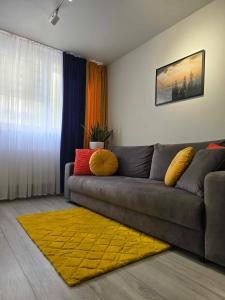 a living room with a couch and a yellow rug at Apartament Pod Jedynką in Bielsko-Biała