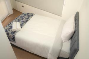 a small bedroom with a bed with white sheets and pillows at COCOA APARTMENTS in Cota