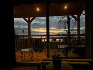 a view of a sunset from the porch of a house at Camping Kleine Belterwijde, Wiede Lodge met uitzicht over het water in Belt-Schutsloot