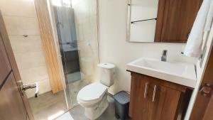 a bathroom with a toilet and a sink and a shower at COCOA APARTMENTS in Cota